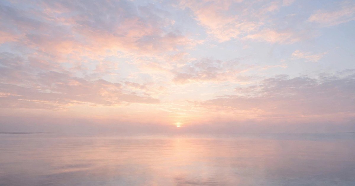 Sunrise over a calm sea horizon, peaceful new beginning